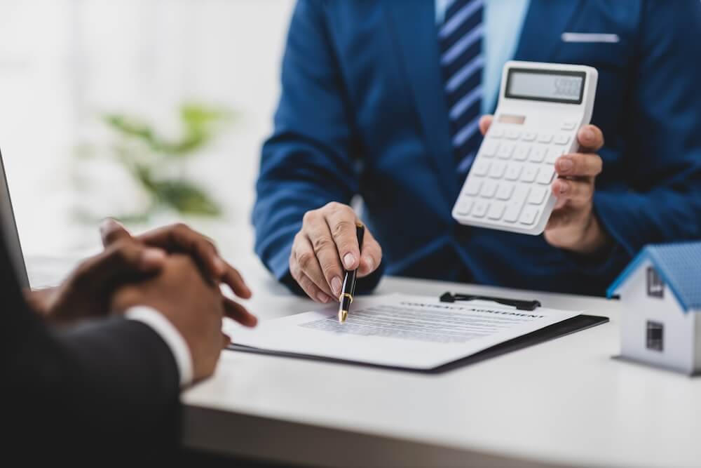Closeup image of a tax advisor showing a client a calculator and their savings